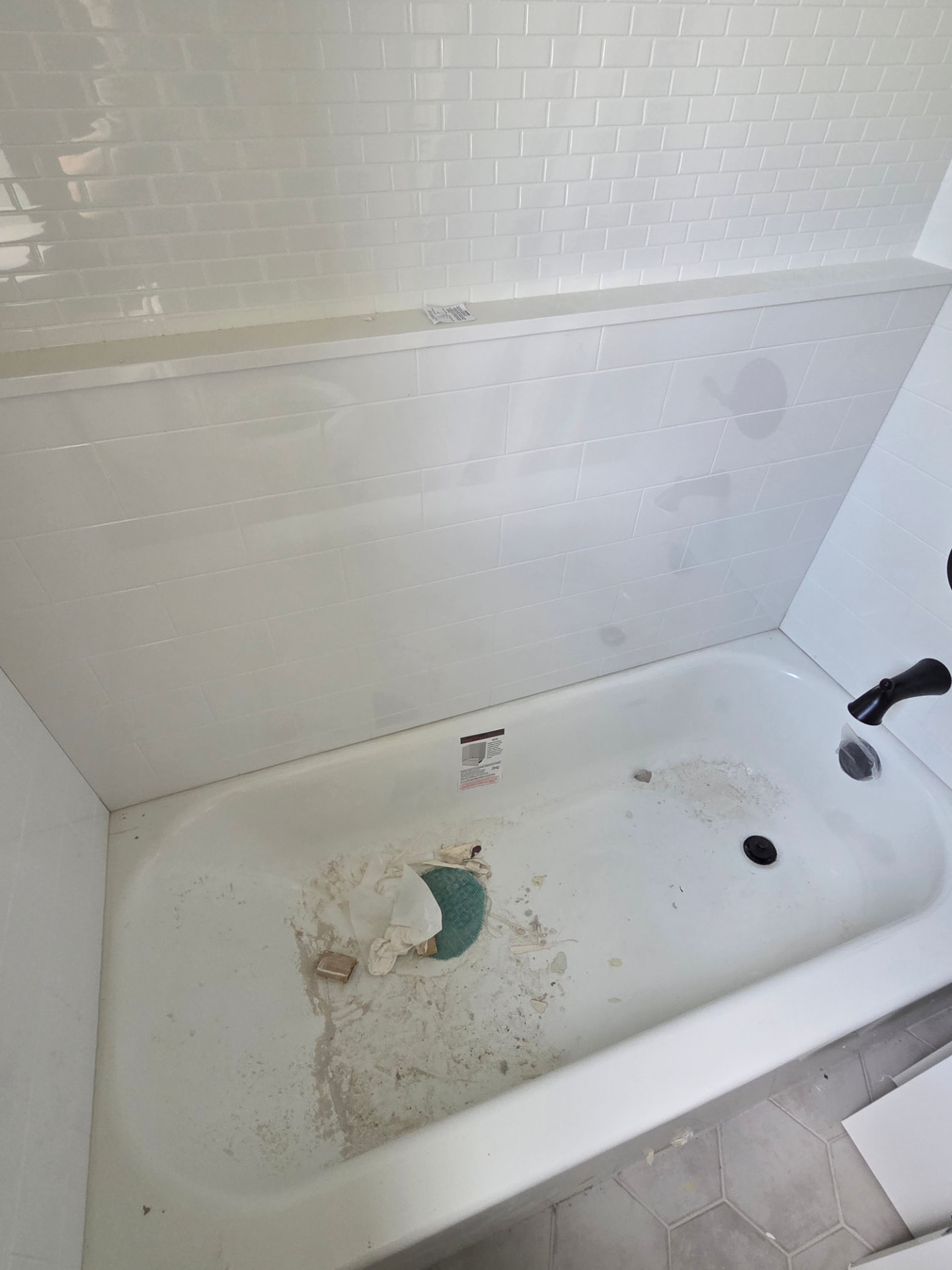 Bathtub before and after post-construction cleaning — before